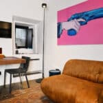 Particolari soggiorno divano velluto e quadro con pistola
